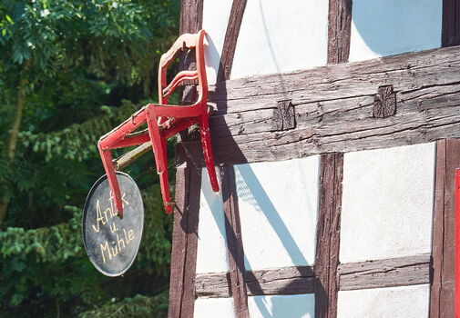 Detail mit rotem Stuhl und Fachwerk an der Öl- und Graupenmühle in Mühlberg